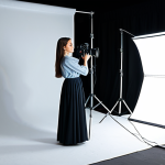 "Mastering Light"**

A professional photographer in a well-lit tent studio, adjusting a softbox lighting a fully clothed model in elegant, modest clothing.  The scene includes various photography equipment like cameras, lenses, and reflectors.  Emphasis on the play of light and shadow on the model's face.  Safe for work, appropriate content, professional, perfect anatomy, natural proportions, high-quality photography, realistic, fully clothed, modest attire.

**